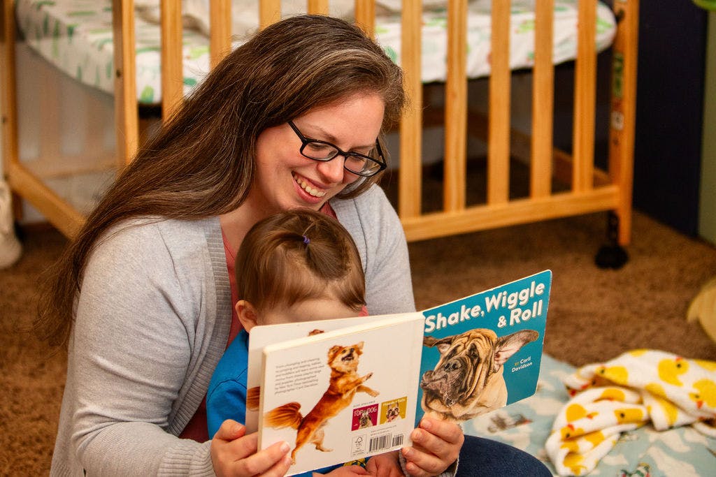 Person and child reading a book together