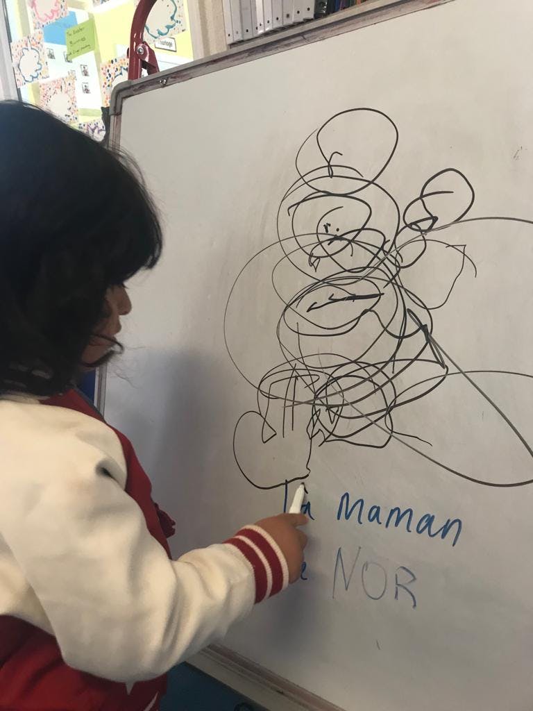 Child drawing on a whiteboard with a marker