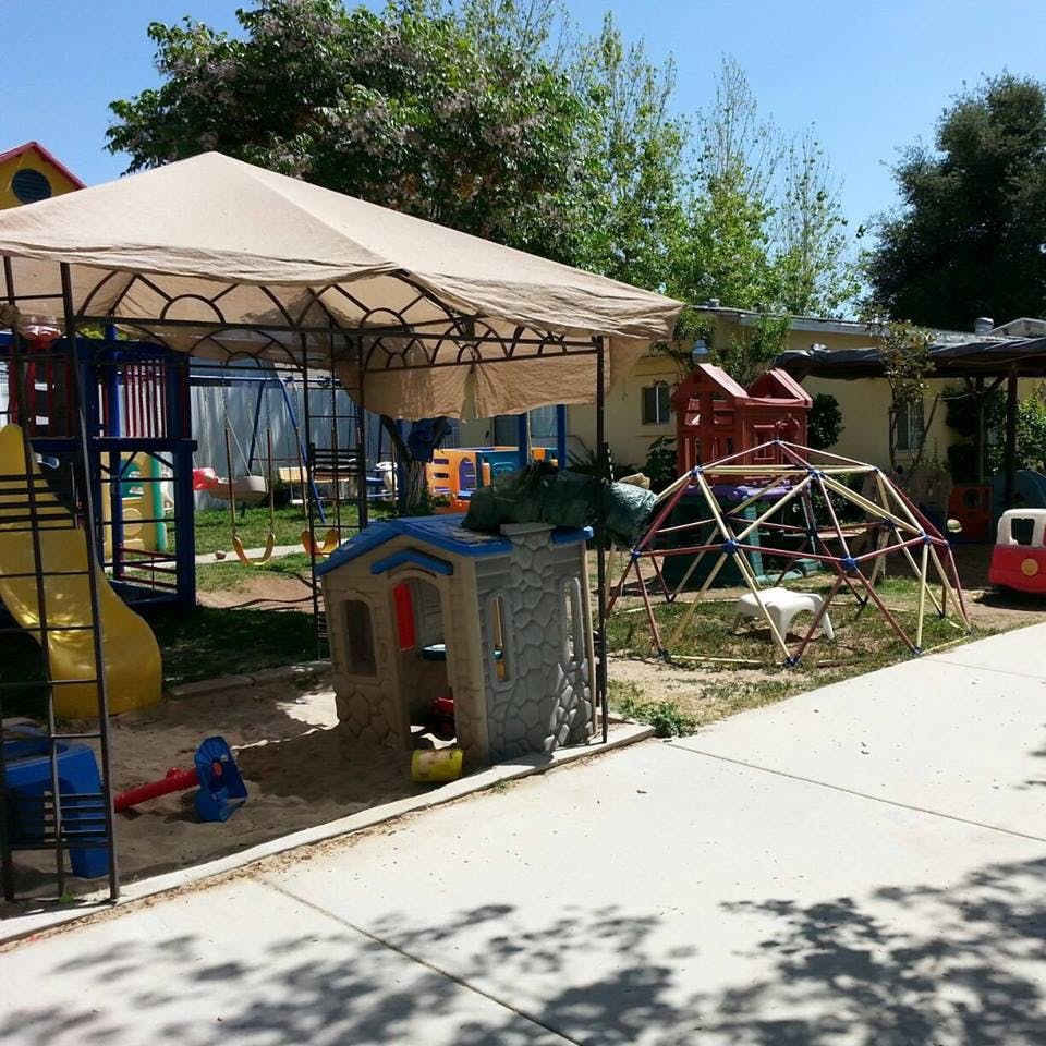 Outdoor playground with play structures, slide, and climbing dome