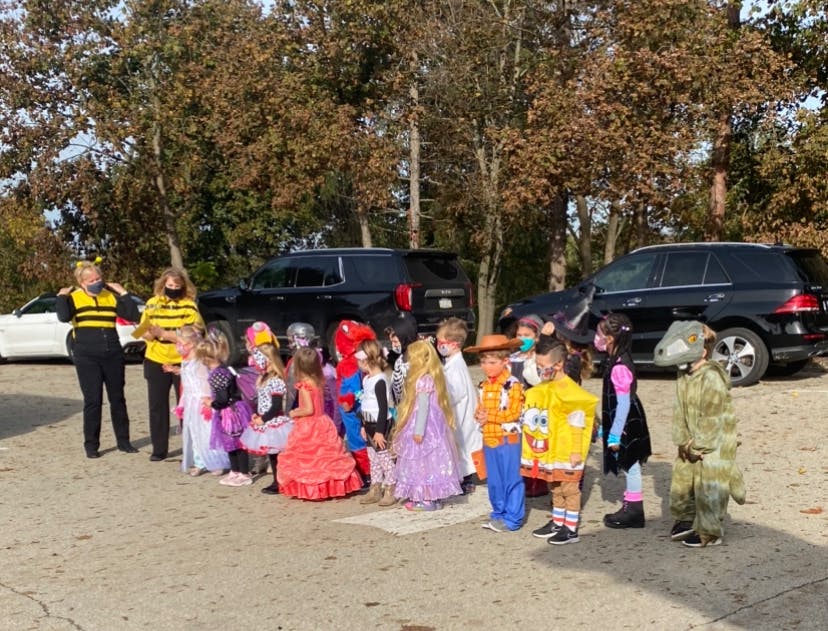 Two people in bee costumes with children in various costumes