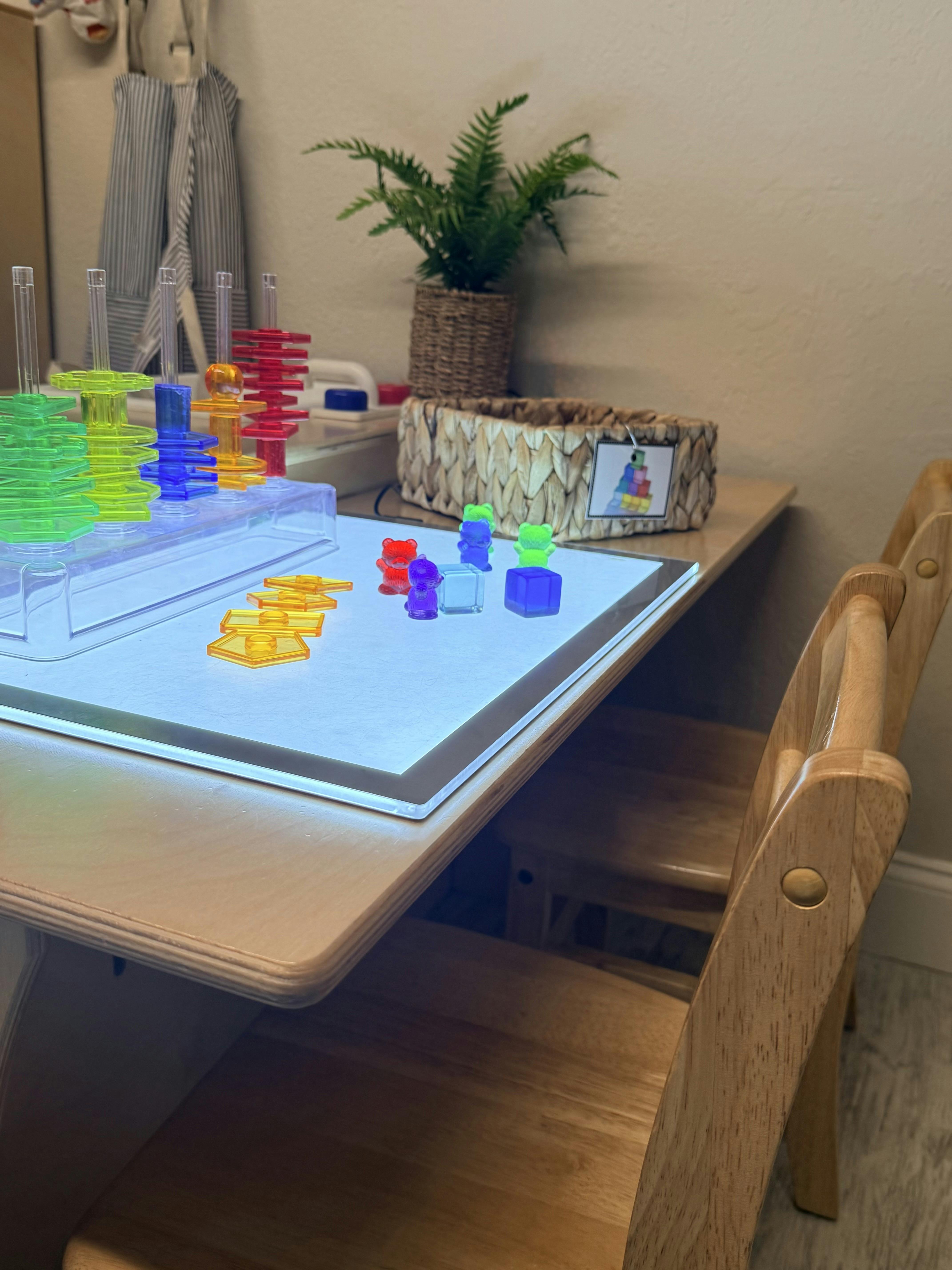 A light table with colorful translucent stacking toys and bear figures