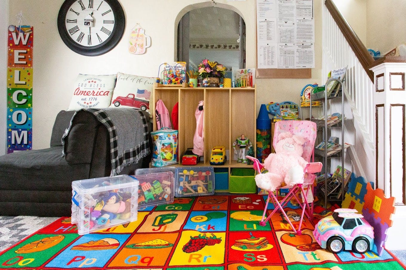 Playroom with colorful alphabet rug, toys, and storage shelves