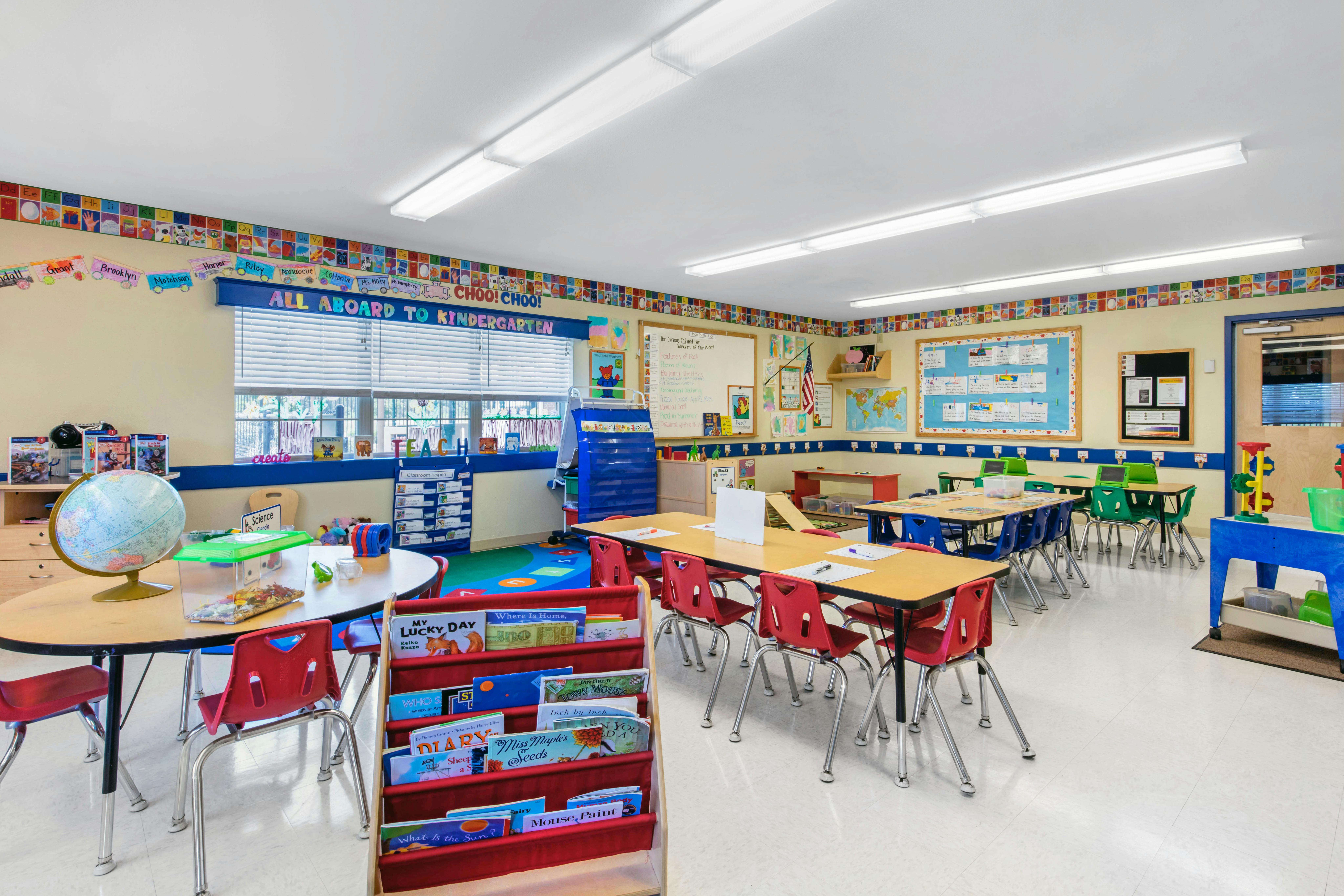 Empty kindergarten classroom with small tables and chairs