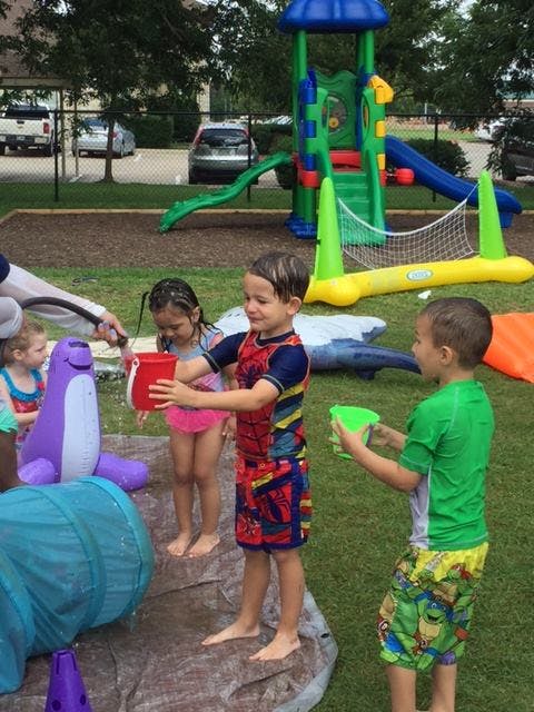 Children playing with water and buckets outdoors