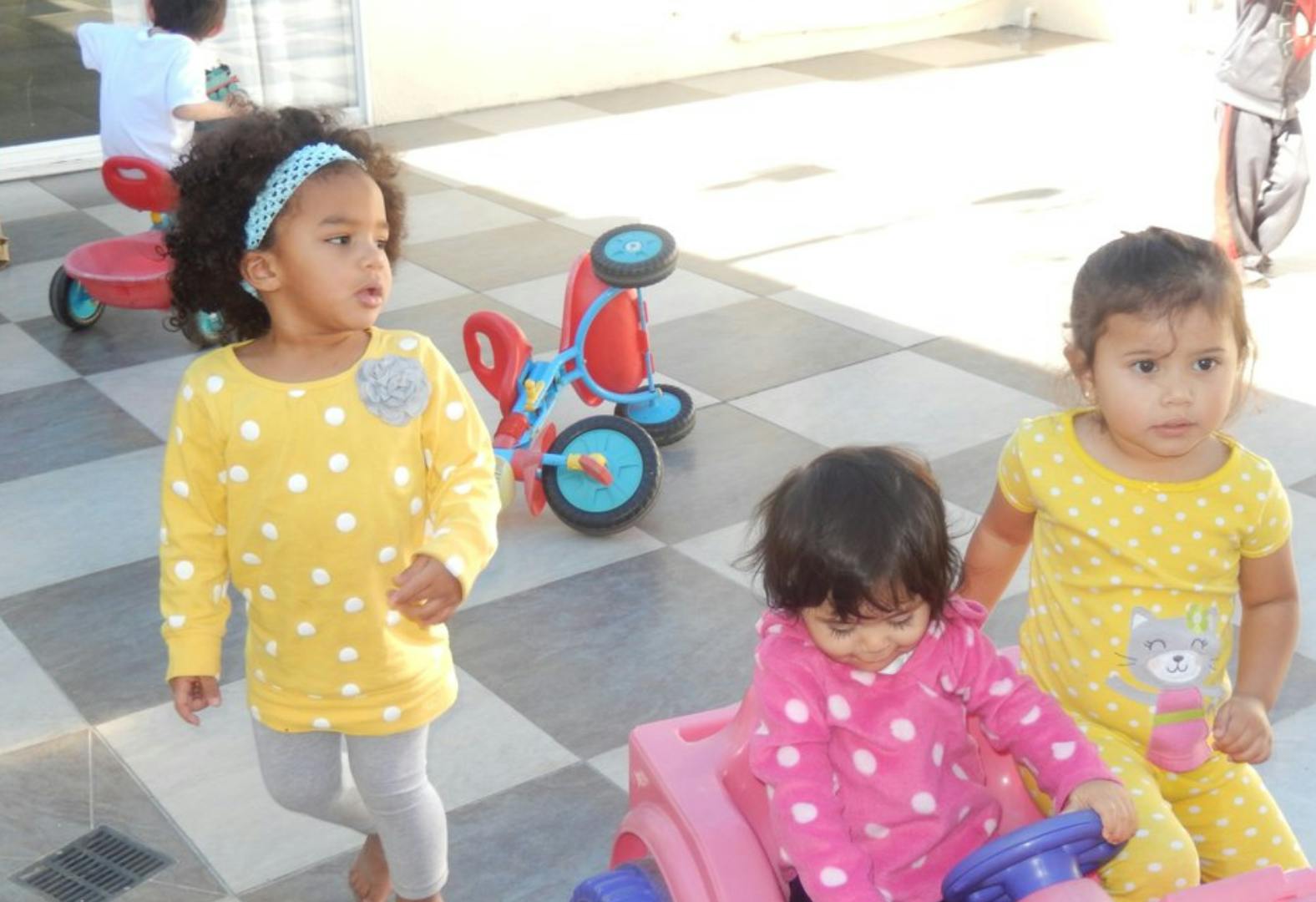 Three children playing with toys outdoors