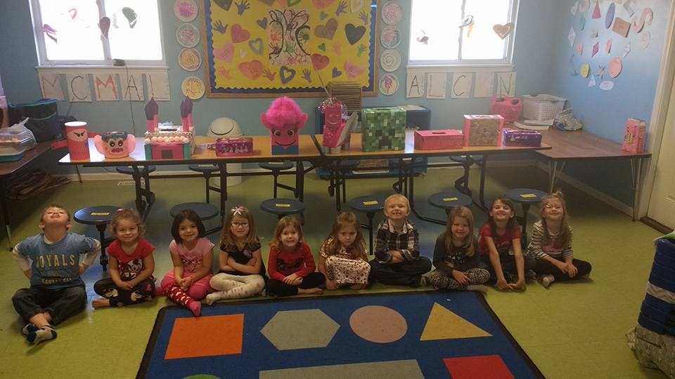 Children sitting on a rug in a classroom