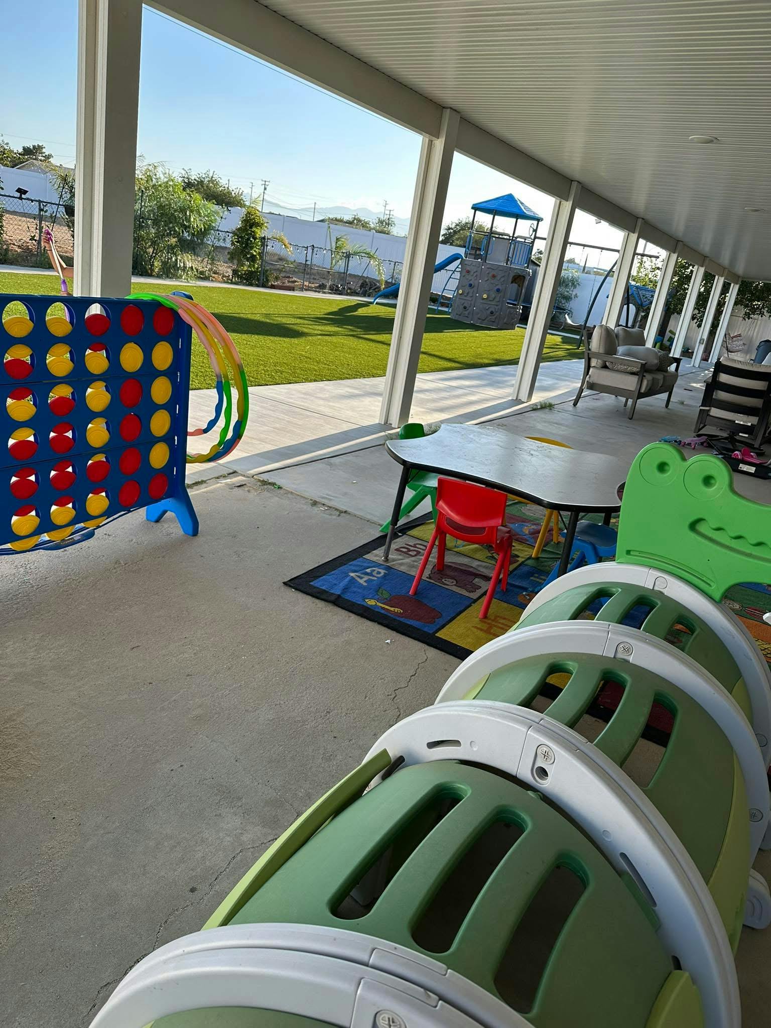 Play area on a patio with children's furniture toys and a game set