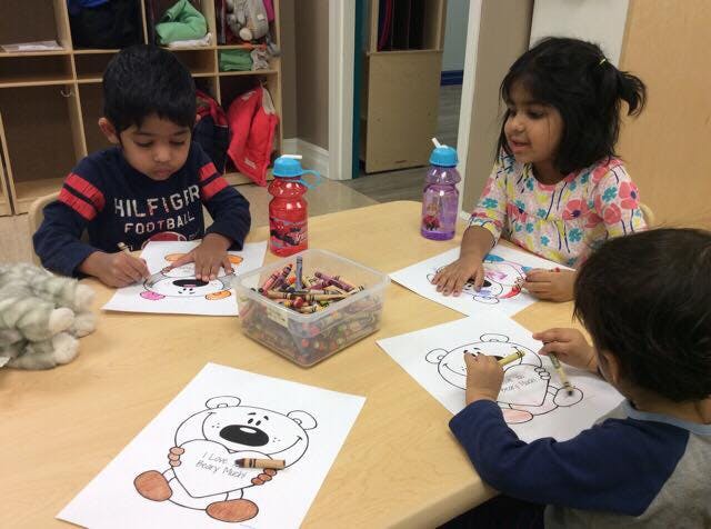 Three children coloring at a table