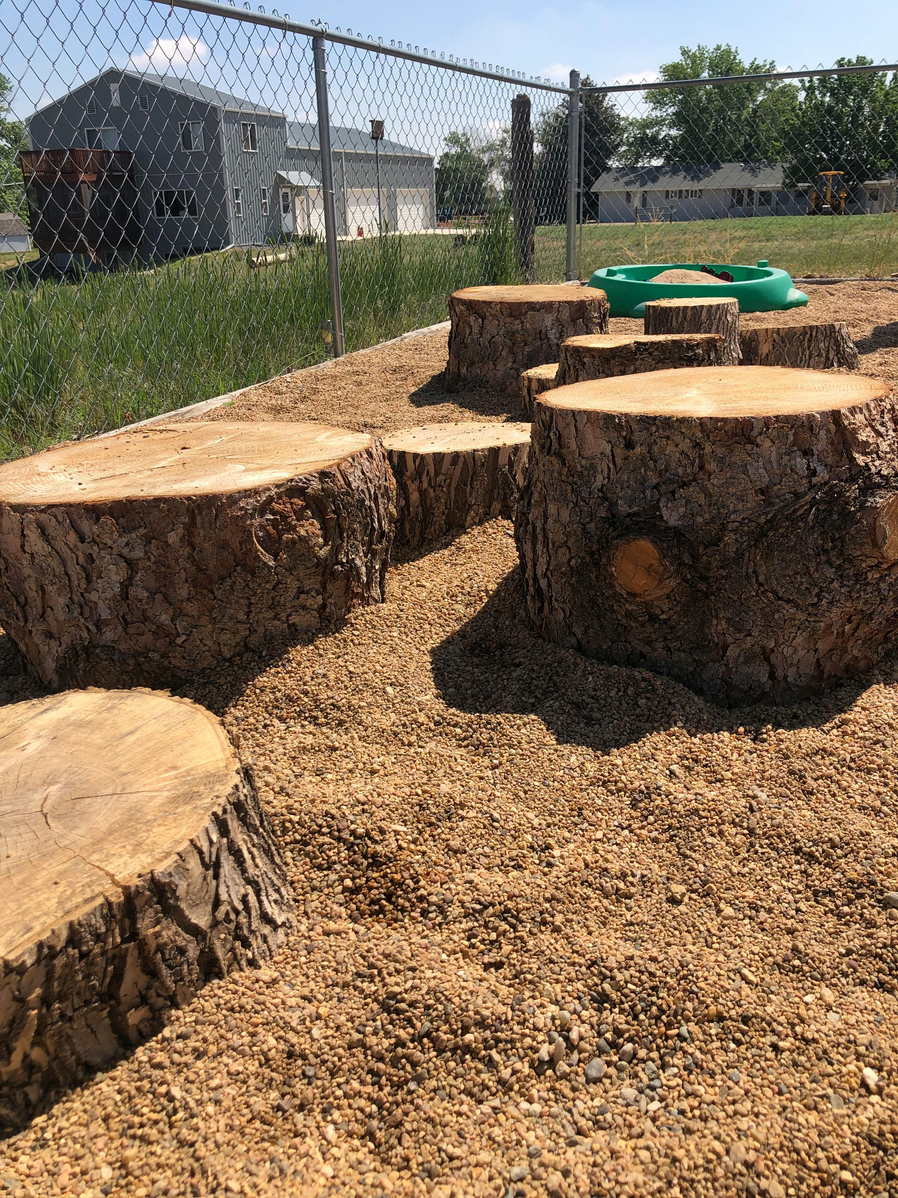Tree stumps on a playground with wood chips