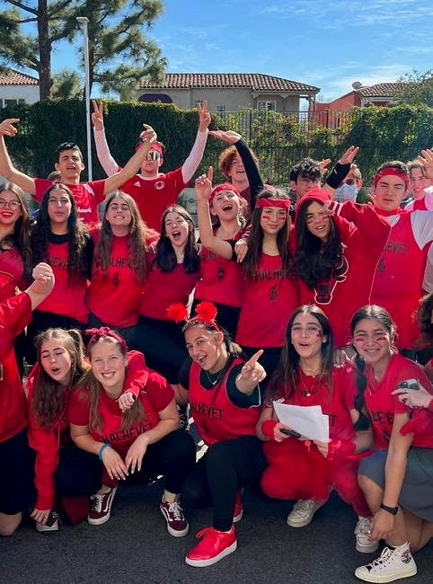 Group of teens in red shirts posing and smiling