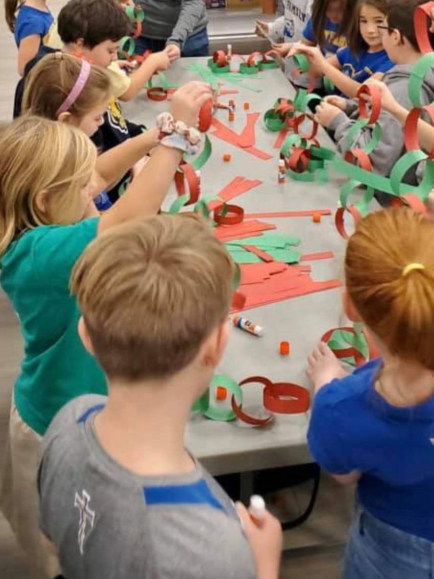 Children making paper chains at a table
