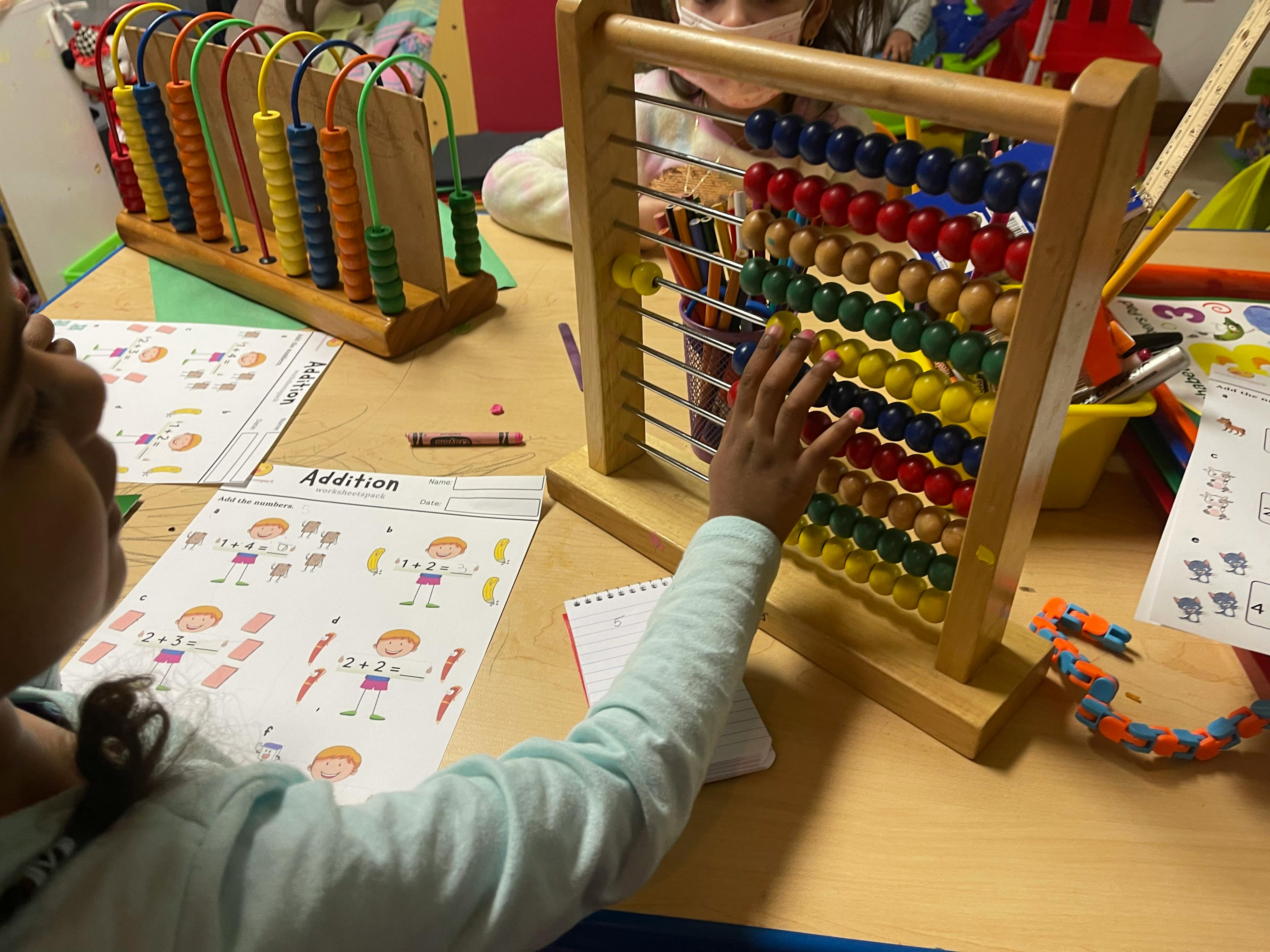 Child using an abacus in a classroom