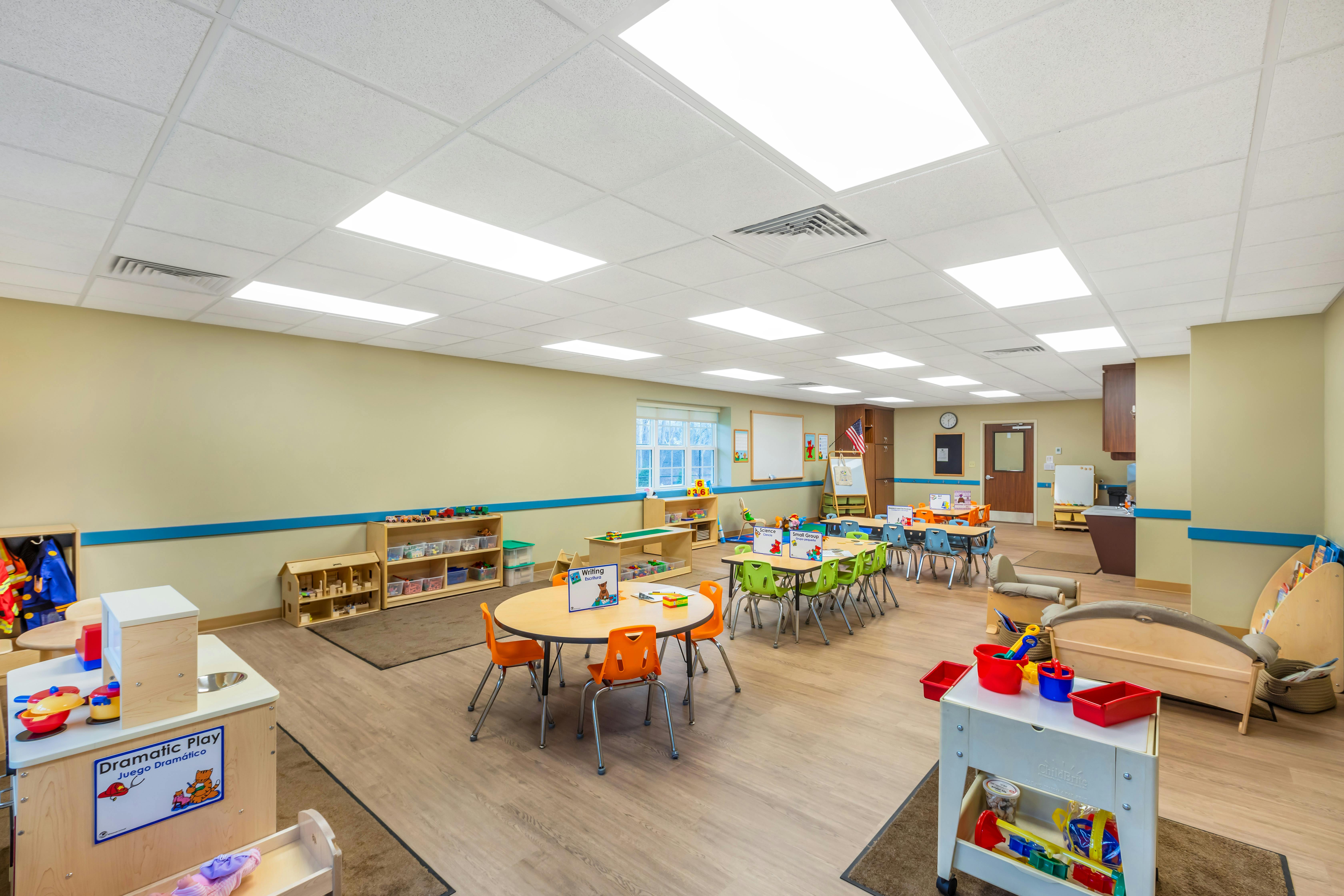 Empty colorful children's classroom with small tables and chairs