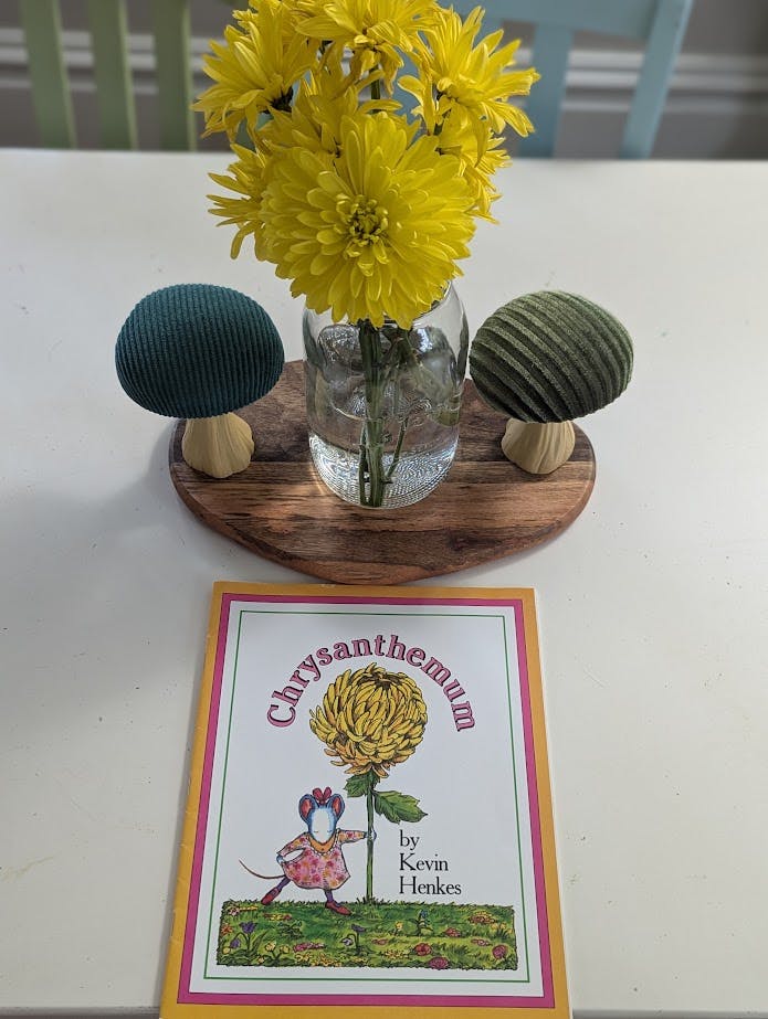 Book "Chrysanthemum" with yellow flowers in a vase and decorative mushrooms