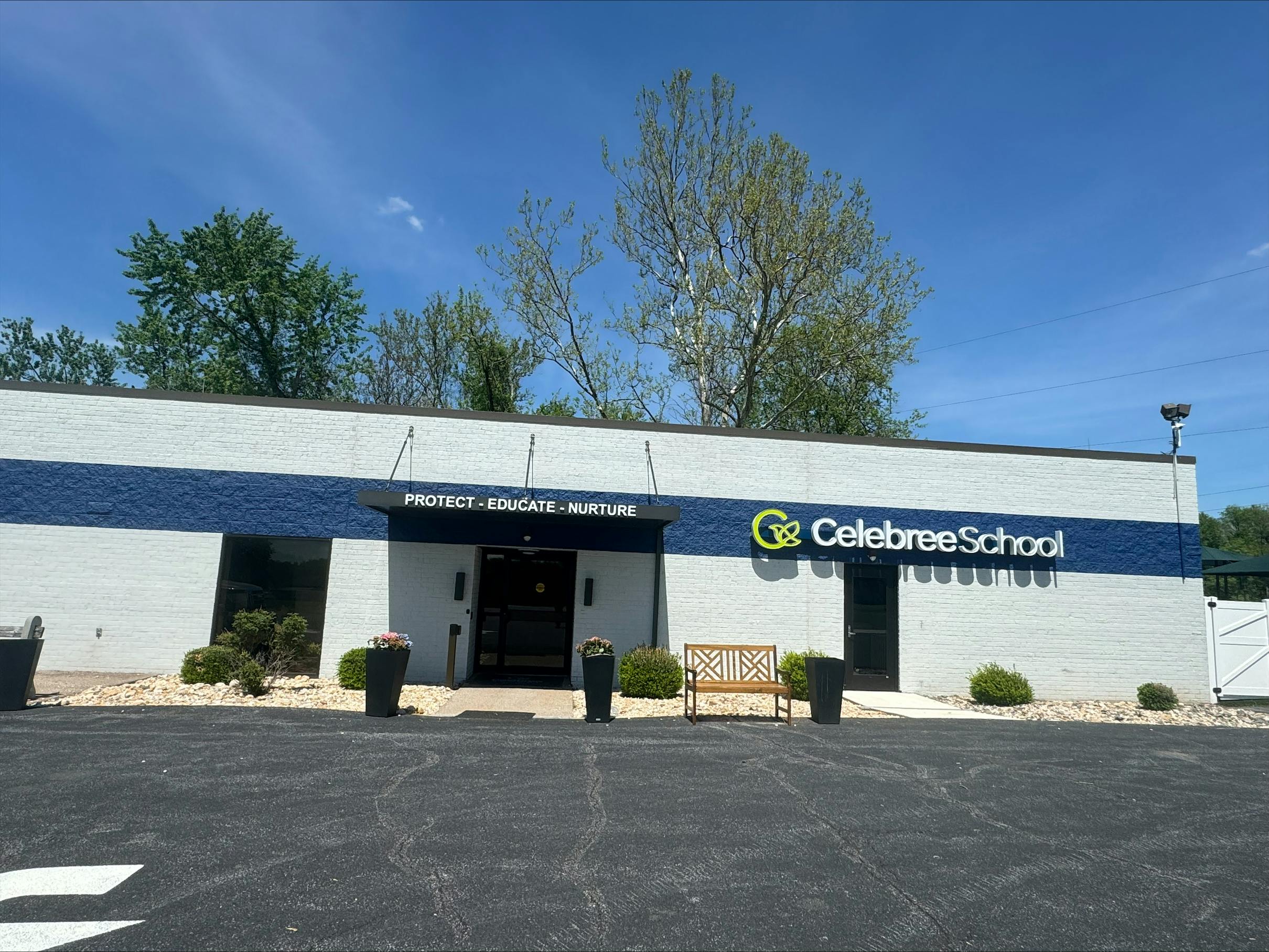 Exterior of Celebree School building with blue stripe and sign