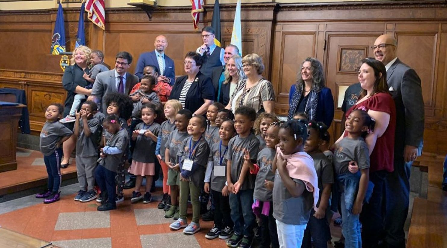 Group of adults and children posing for a photo indoors