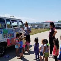 Adults and children gathered around a bookmobile