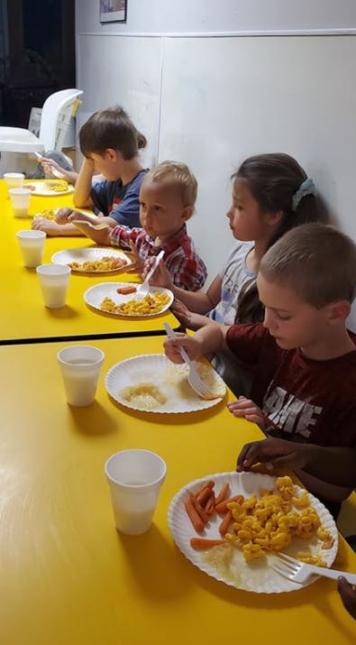 Children eating at a yellow table