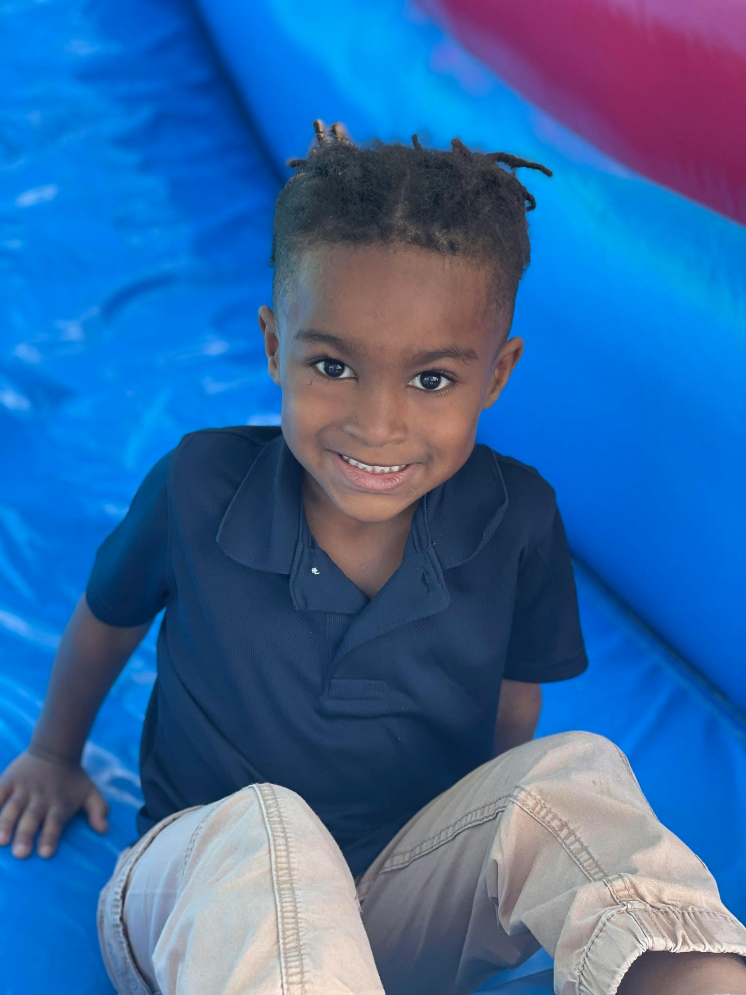 Child sitting on a blue inflatable surface