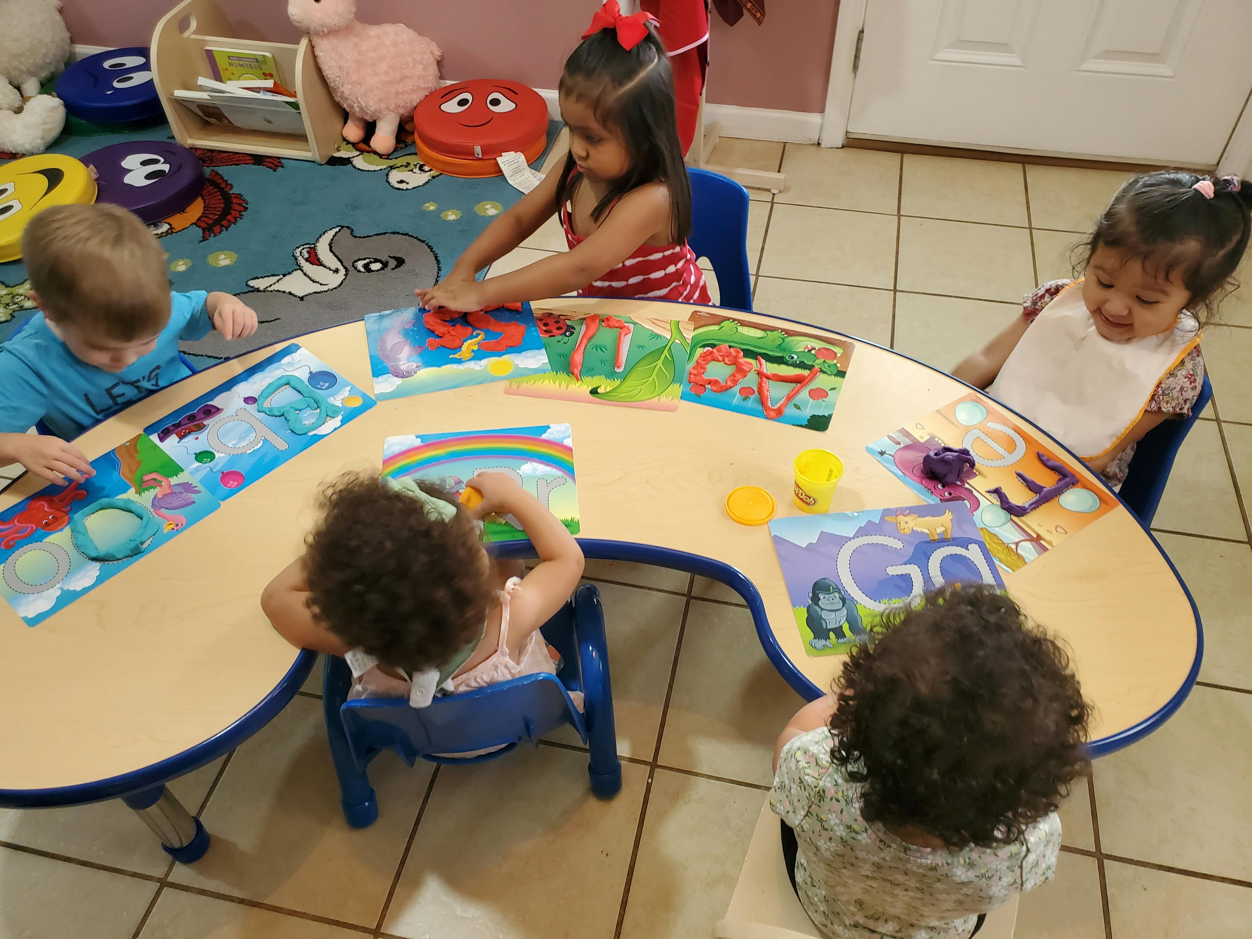 Four children sitting at a table doing crafts