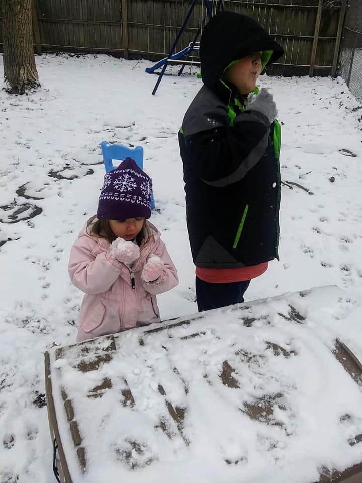 Two children playing in the snow