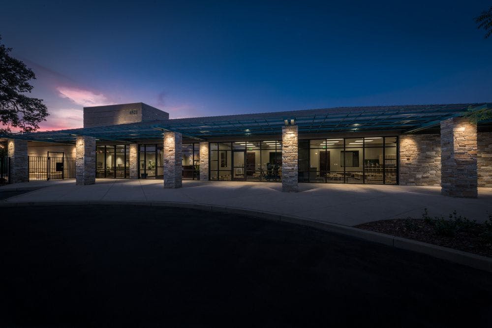 Building exterior with illuminated columns and glass facade at dusk