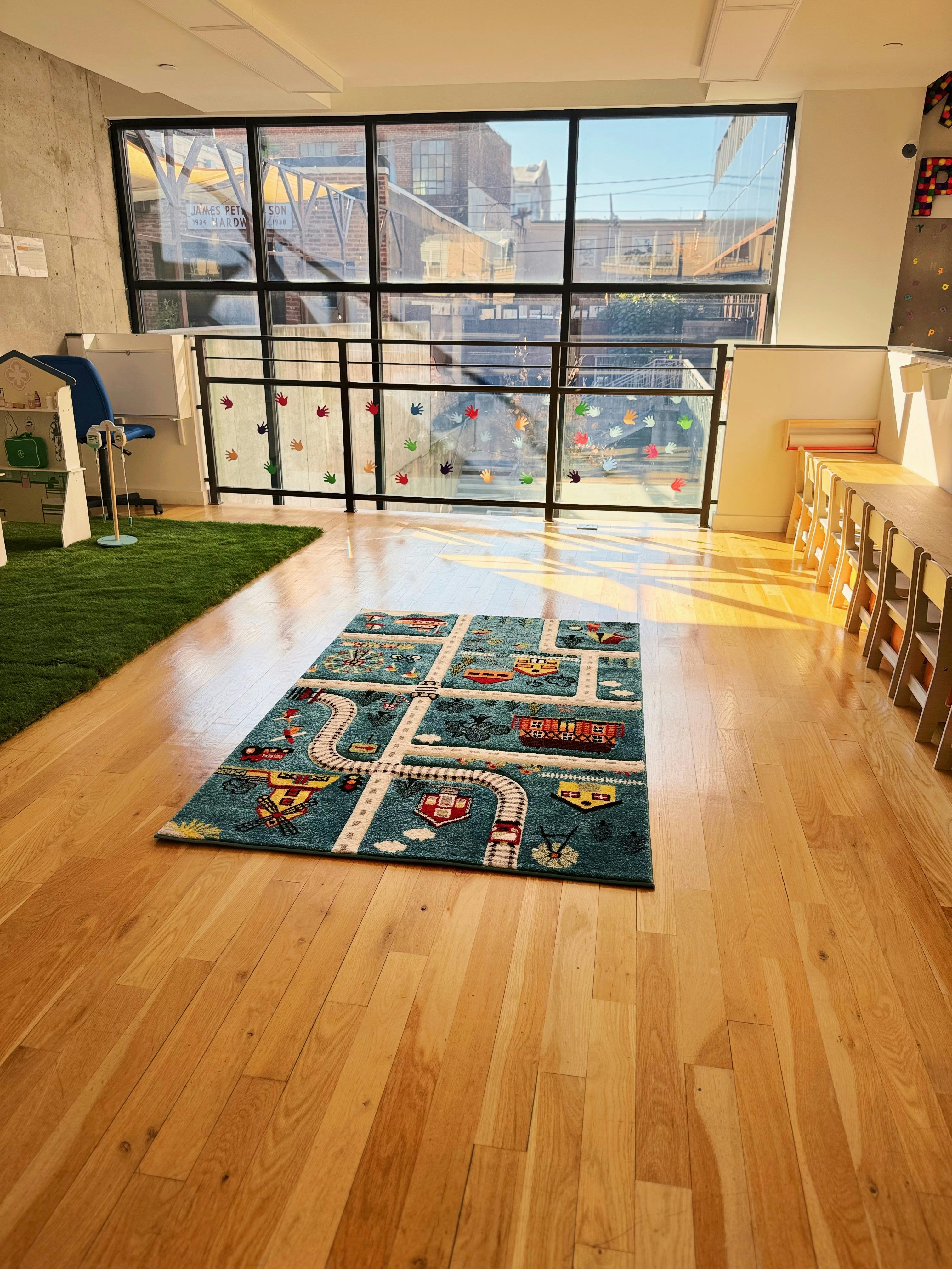 Playroom with a road map rug on a wooden floor and large windows