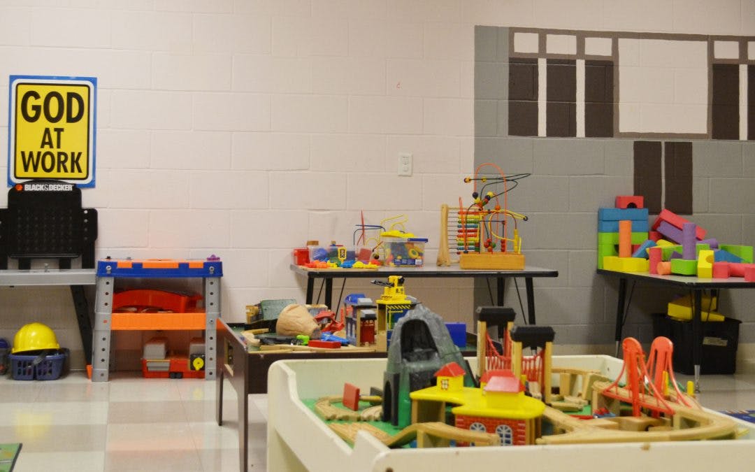 Playroom with tables of toys, including a train set and building blocks