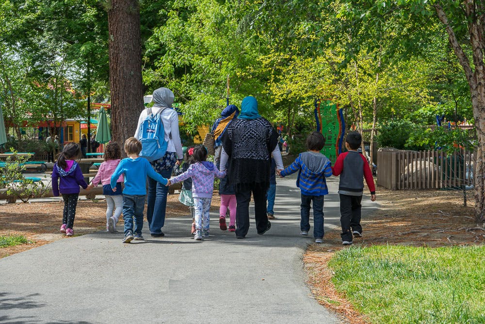 Adults and children walking on a path outdoors