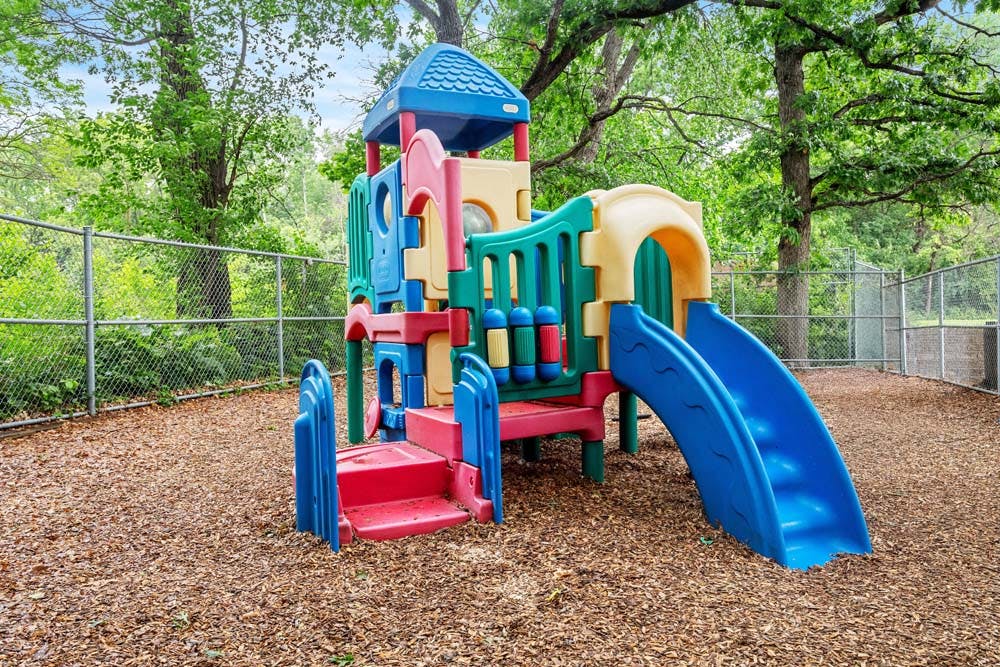 Colorful playground structure with slides on a wood chip ground