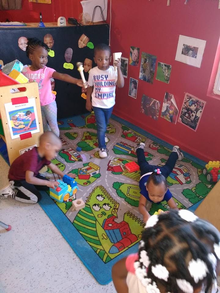 Children playing on a colorful rug in a room
