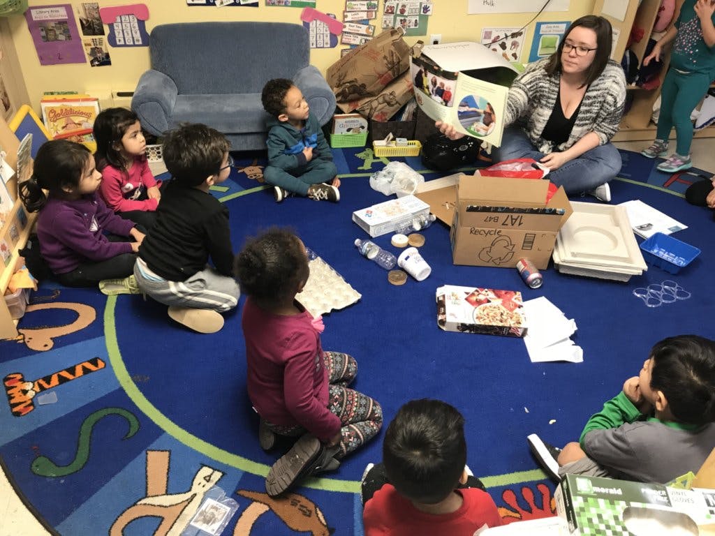 Adult reading to children sitting on a rug in a classroom
