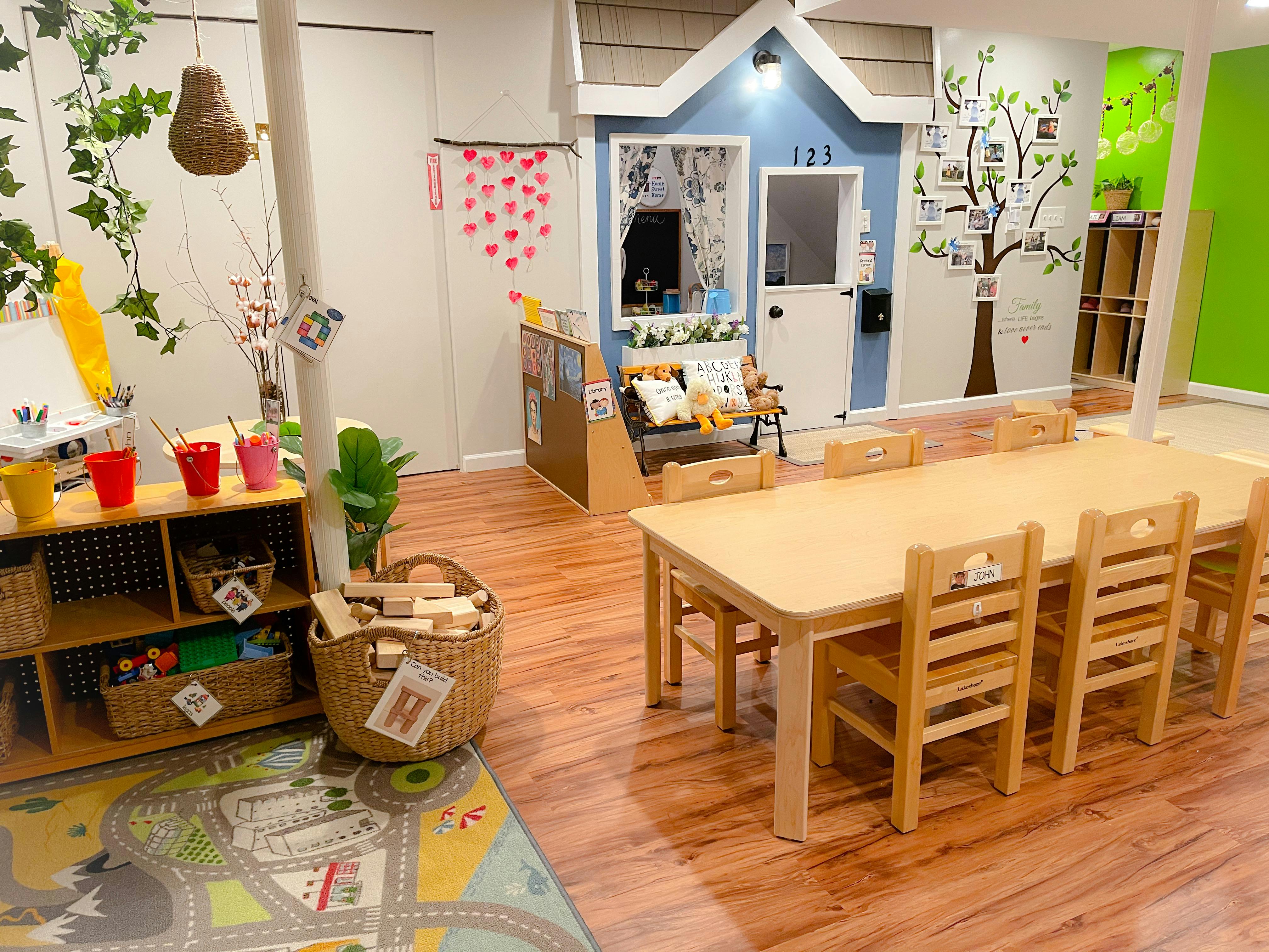 Playroom with a small wooden table and chairs, shelves, and a playhouse
