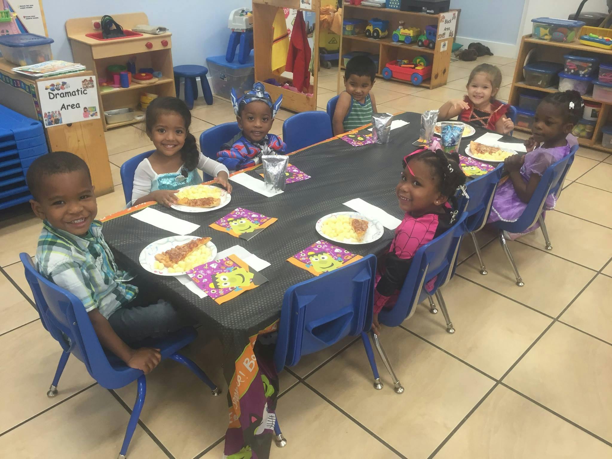 Children sitting at a table with plates of food