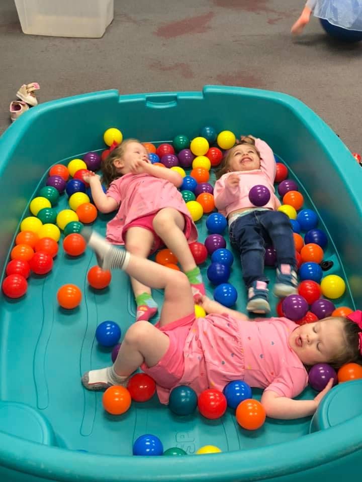 Three children playing in a ball pit