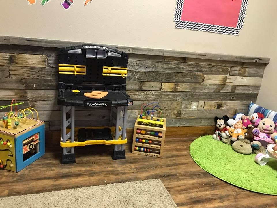 Child's play area with toy workbench, activity cube, and stuffed animals
