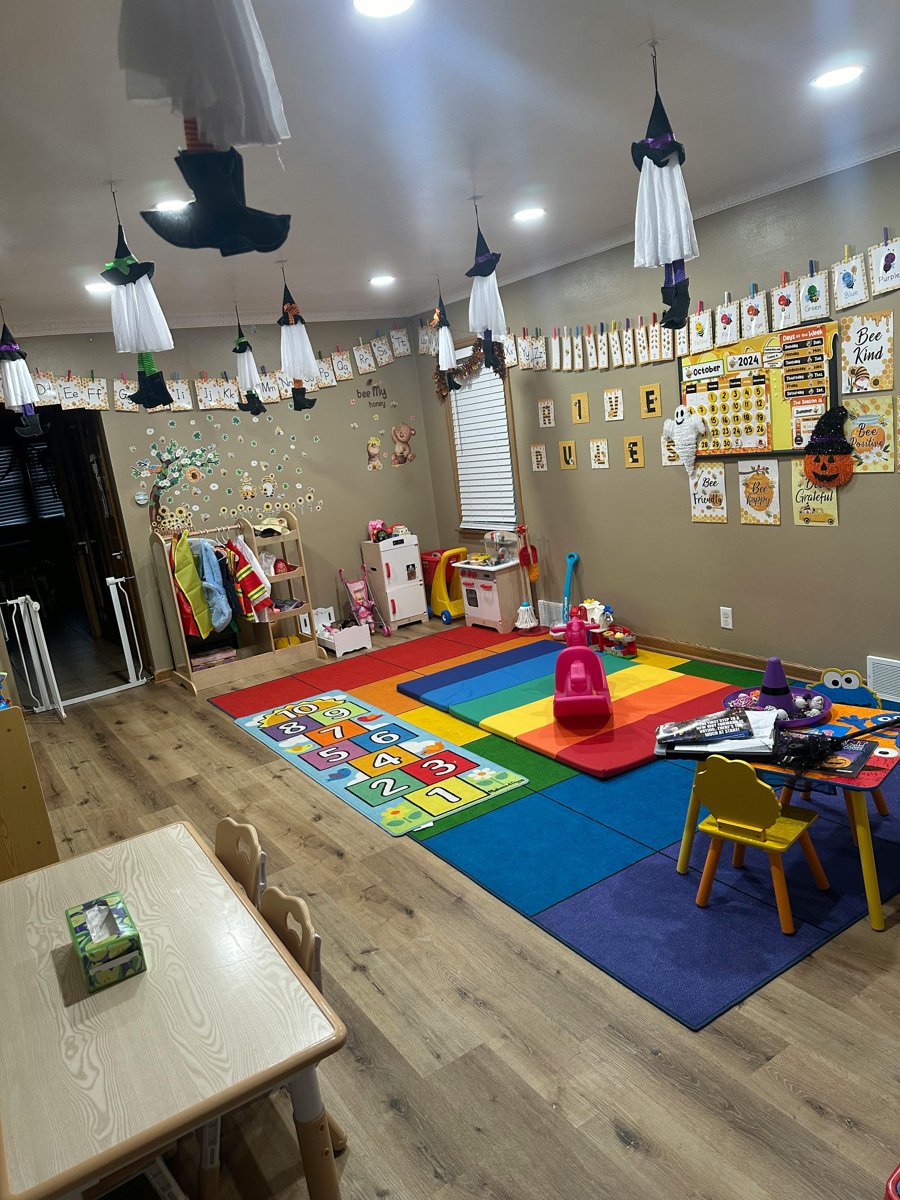 Playroom with colorful mats, small tables, and Halloween decorations