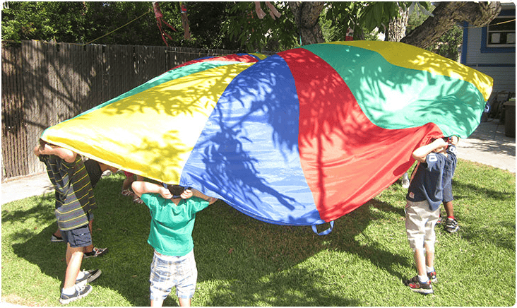 Children holding up a colorful parachute