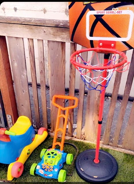 Children's toys including a ride-on toy, a toy lawnmower, and a basketball hoop
