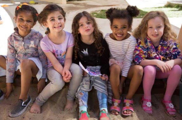 Five children sitting together, smiling