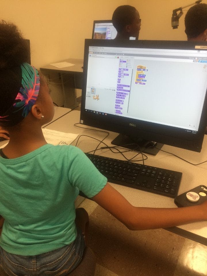 Child looking at a computer screen displaying code blocks of code blocks