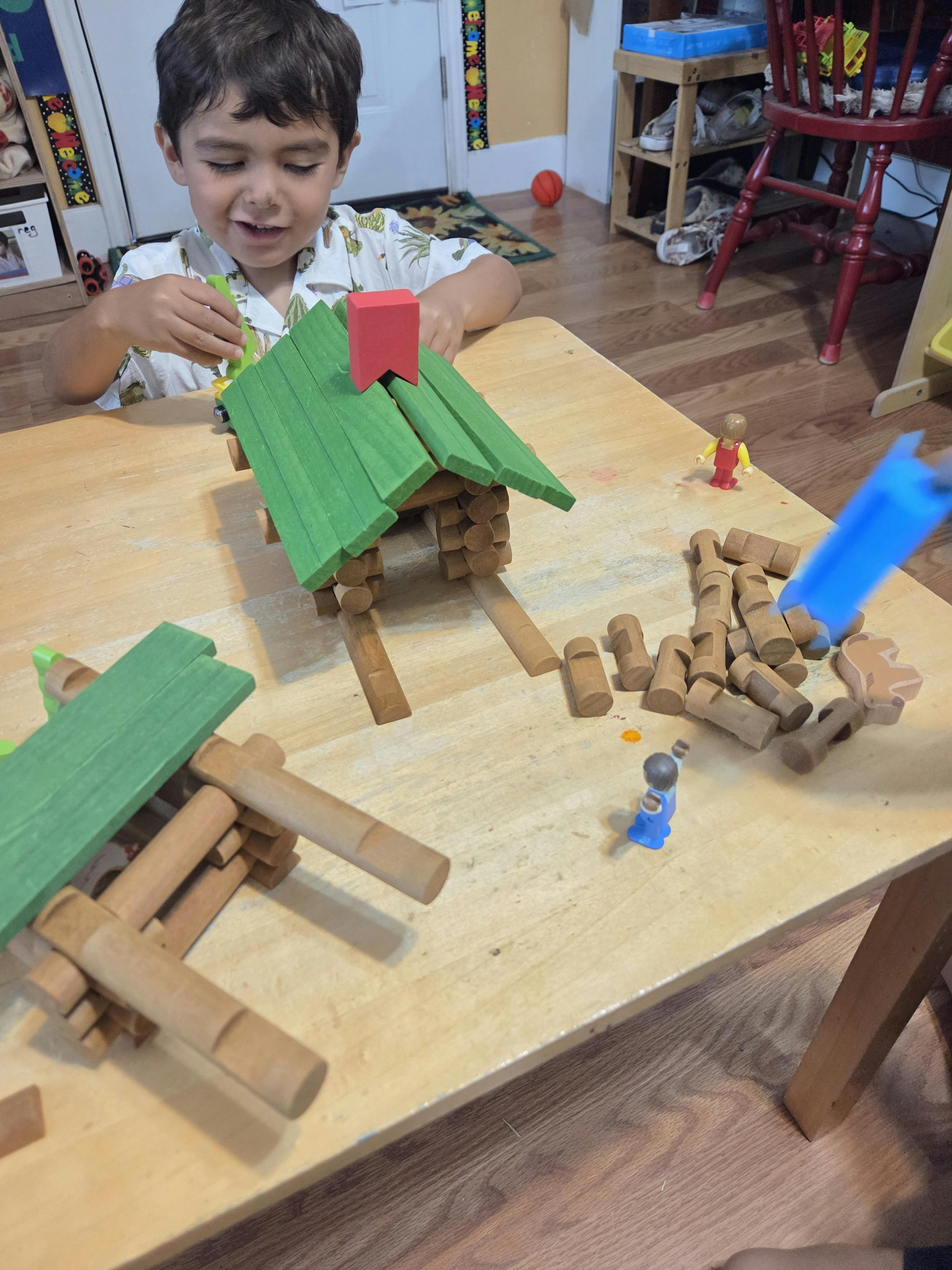 Child building with wooden toy logs at a table