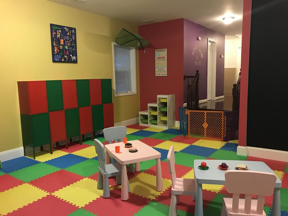 Colorful playroom with small tables and chairs on foam mat flooring