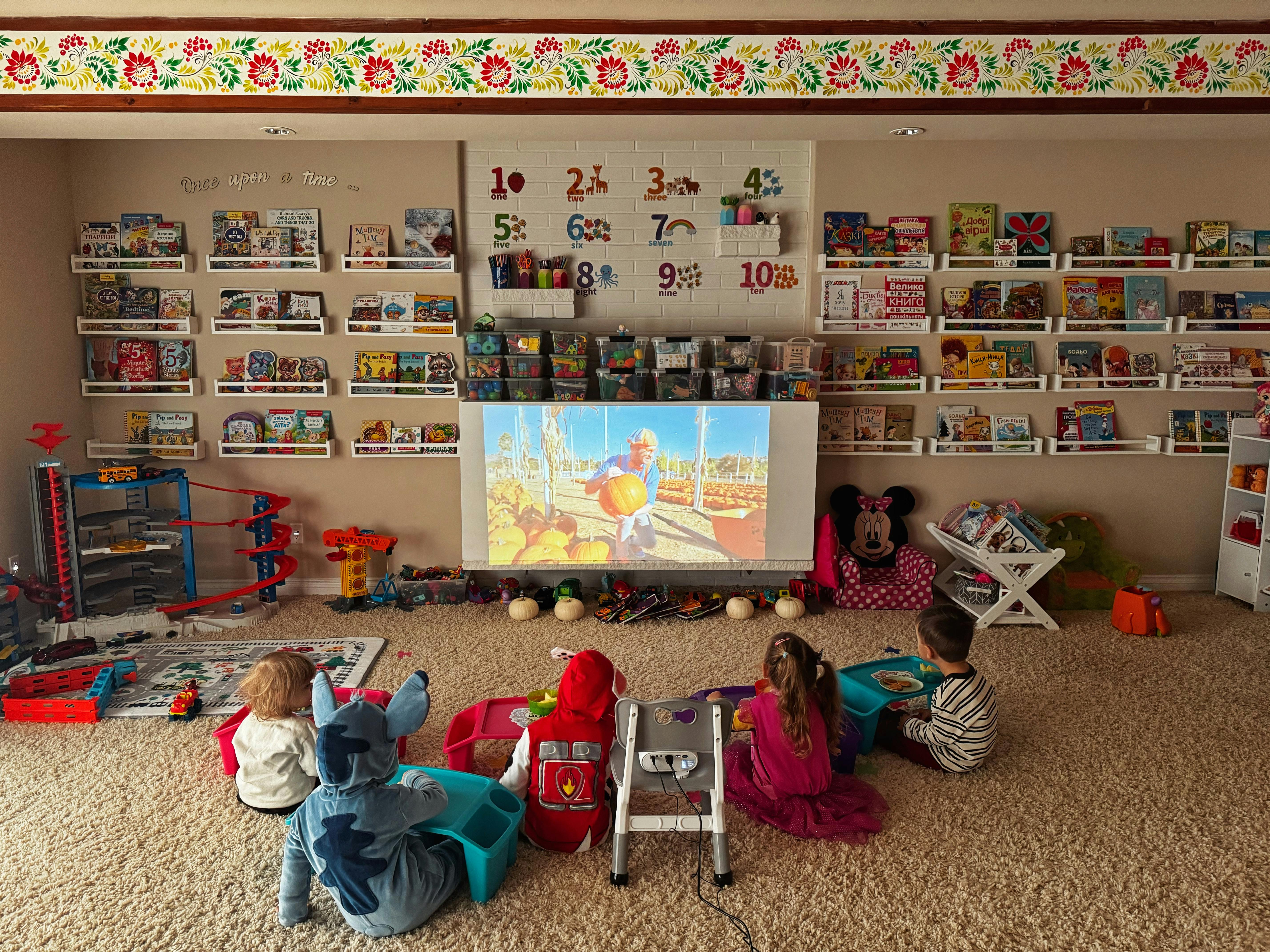 Children watching a projected image in a room with shelves of books