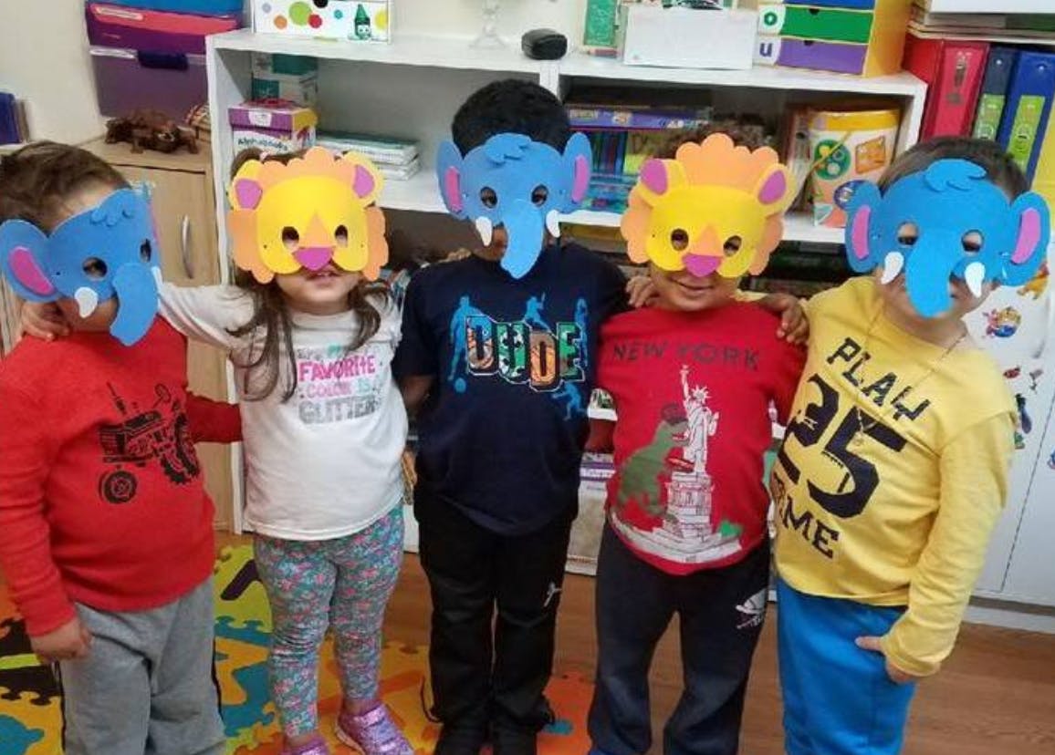 Five children wearing animal masks