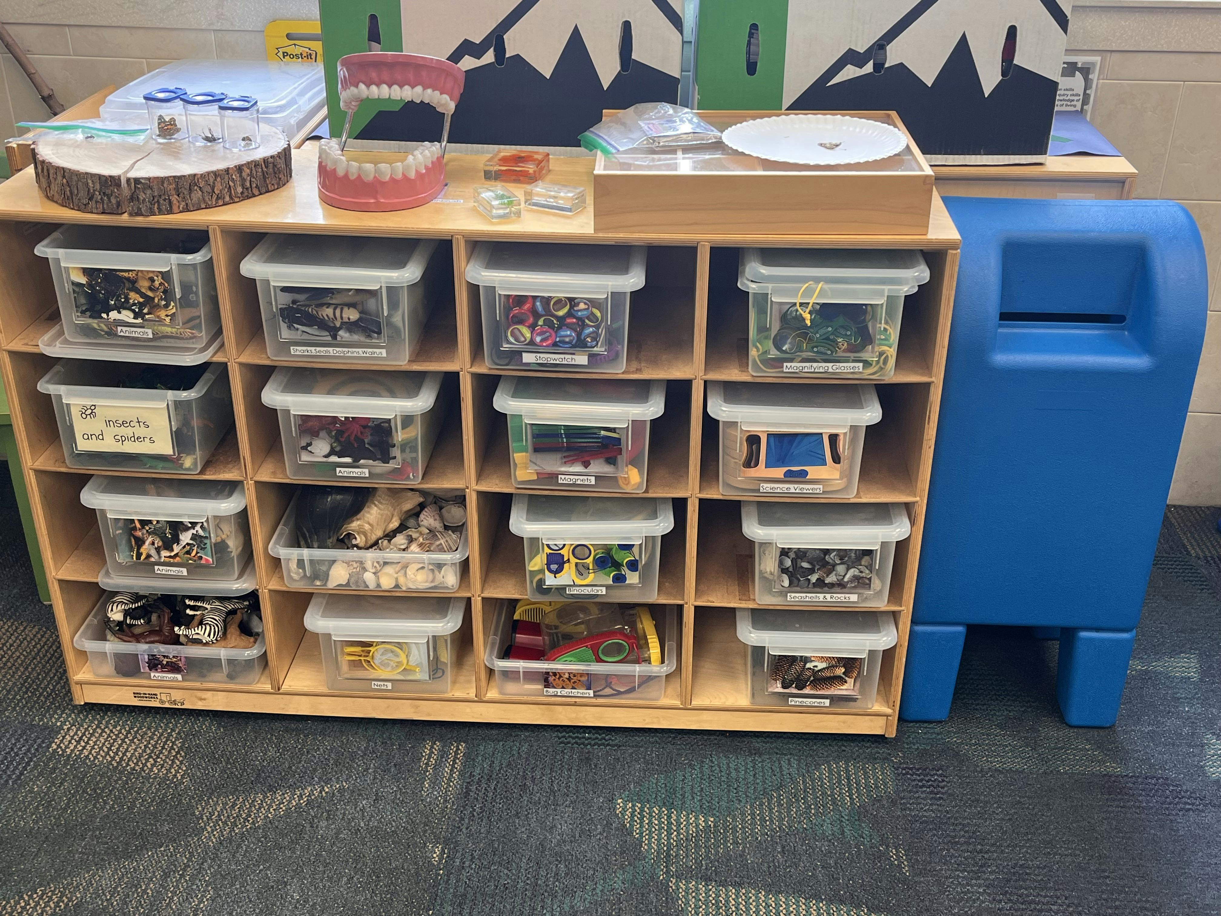 Wooden shelf unit with clear storage bins filled with various items