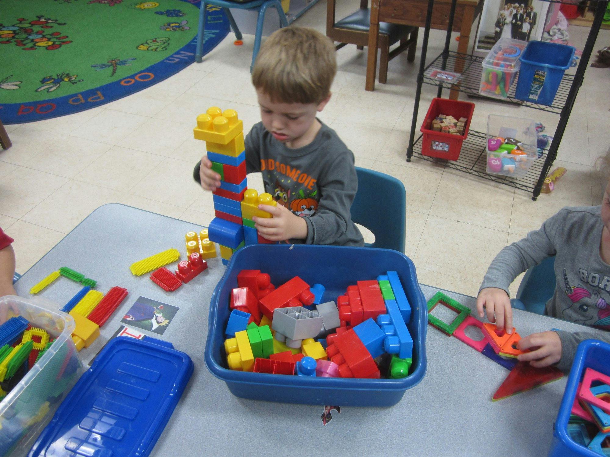 Child building with colorful blocks at a table