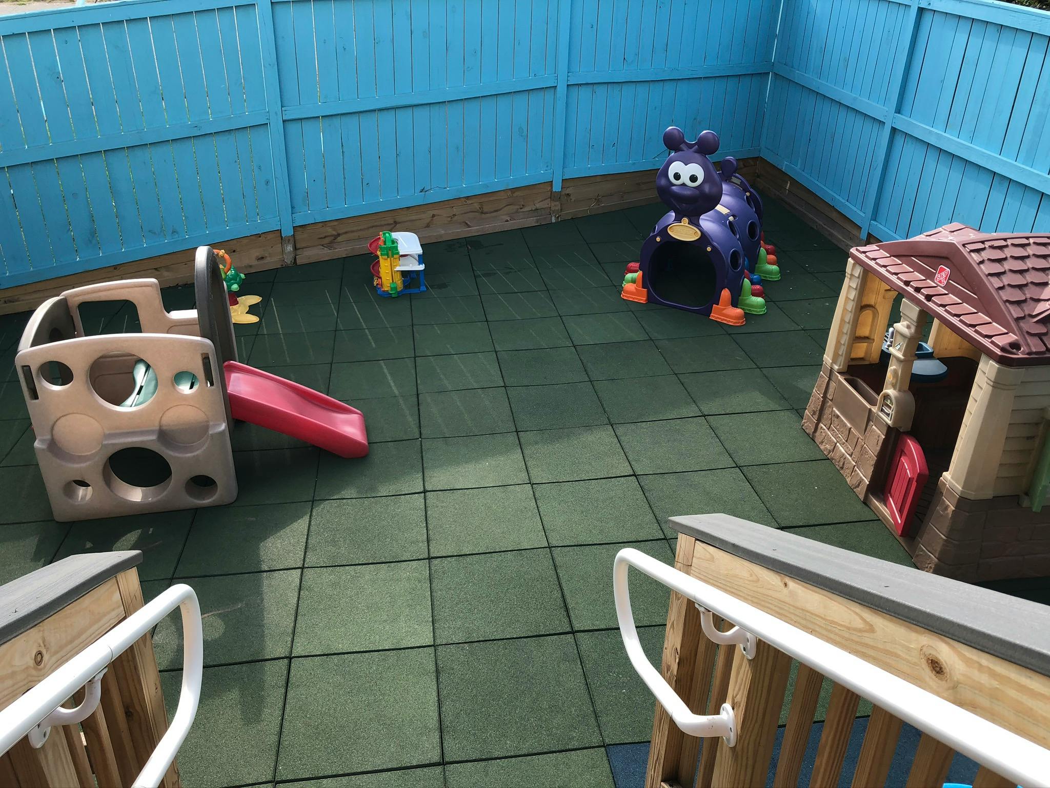Playground with slide, playhouse, and purple ride-on toy