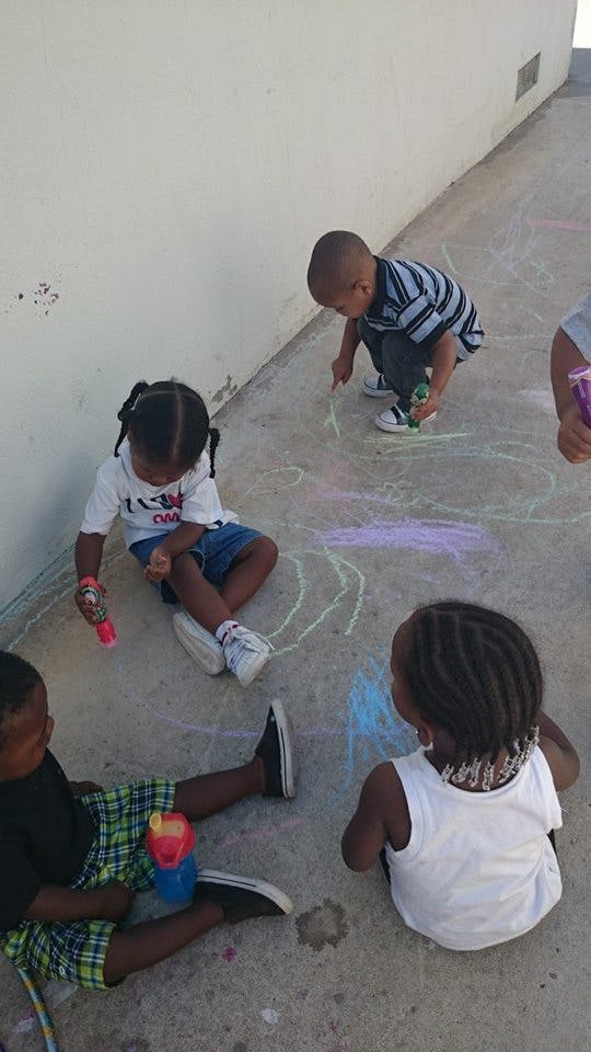 Children drawing with chalk on concrete