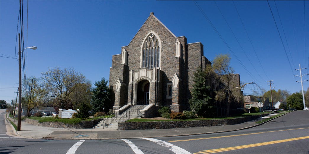 Stone church with large arched window and steps leading steps